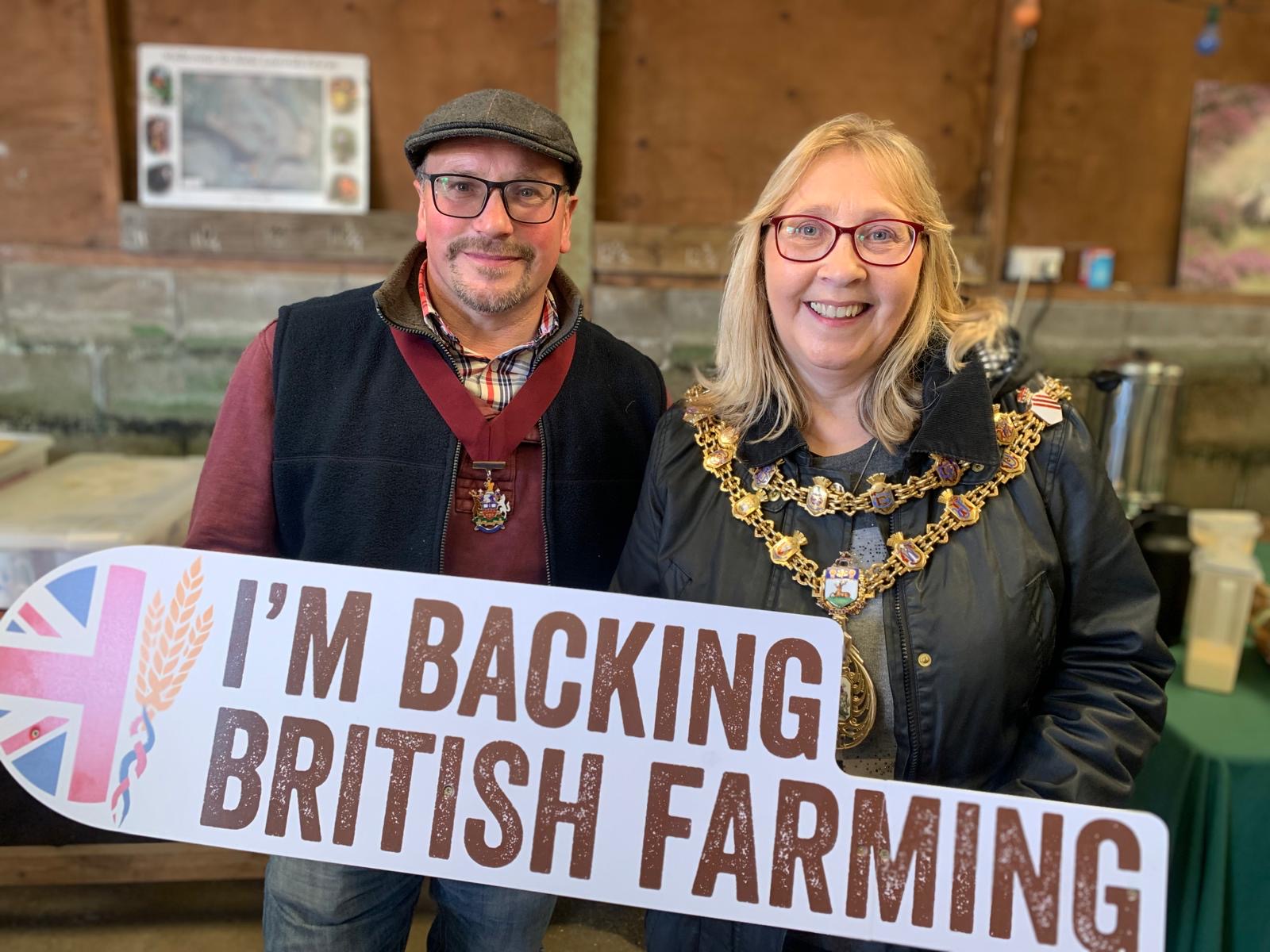 Mayor and consort holding a sign that says I'm backing British farming