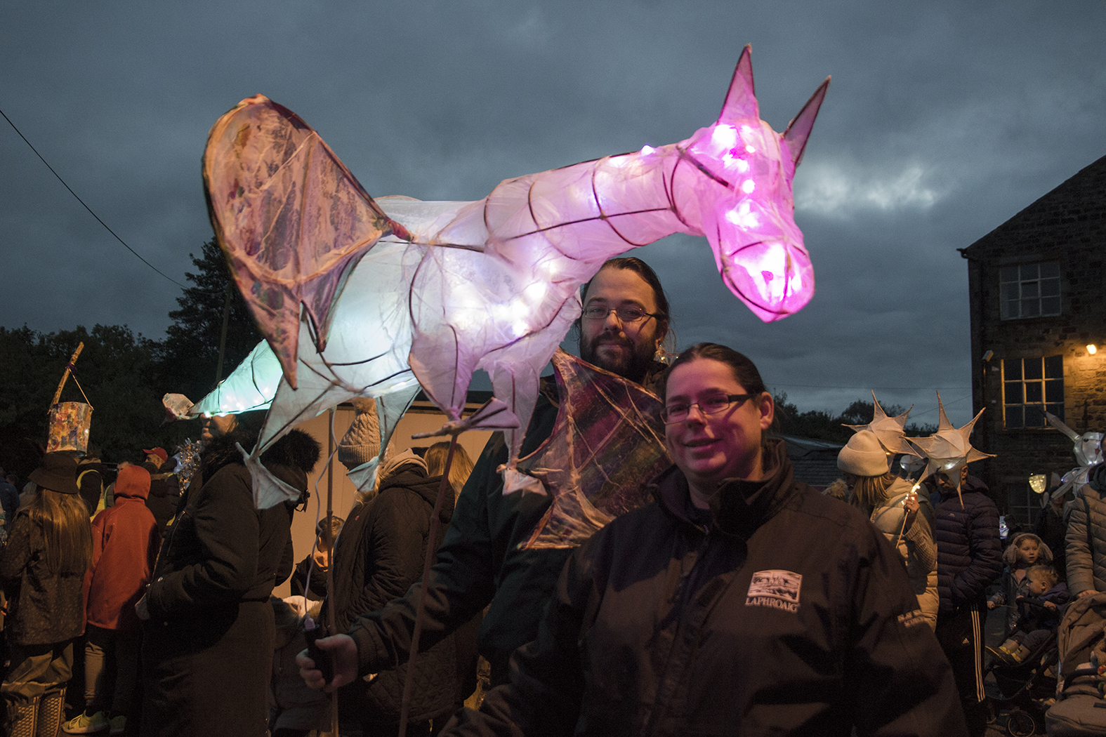 paper lantern of a horse  held up by two people